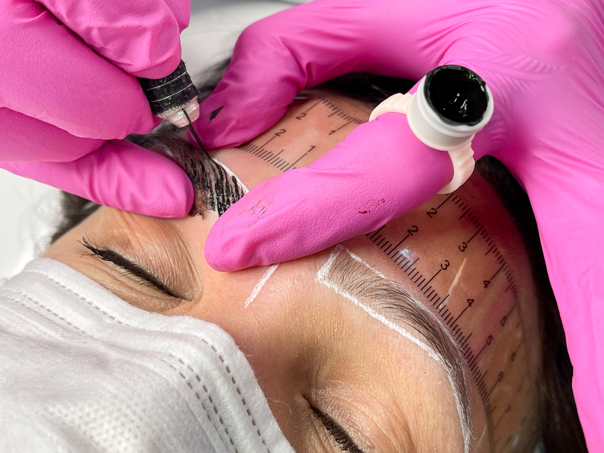 Beautician performing microblading technique in client eyebrow. Thread by thread micropigmentation