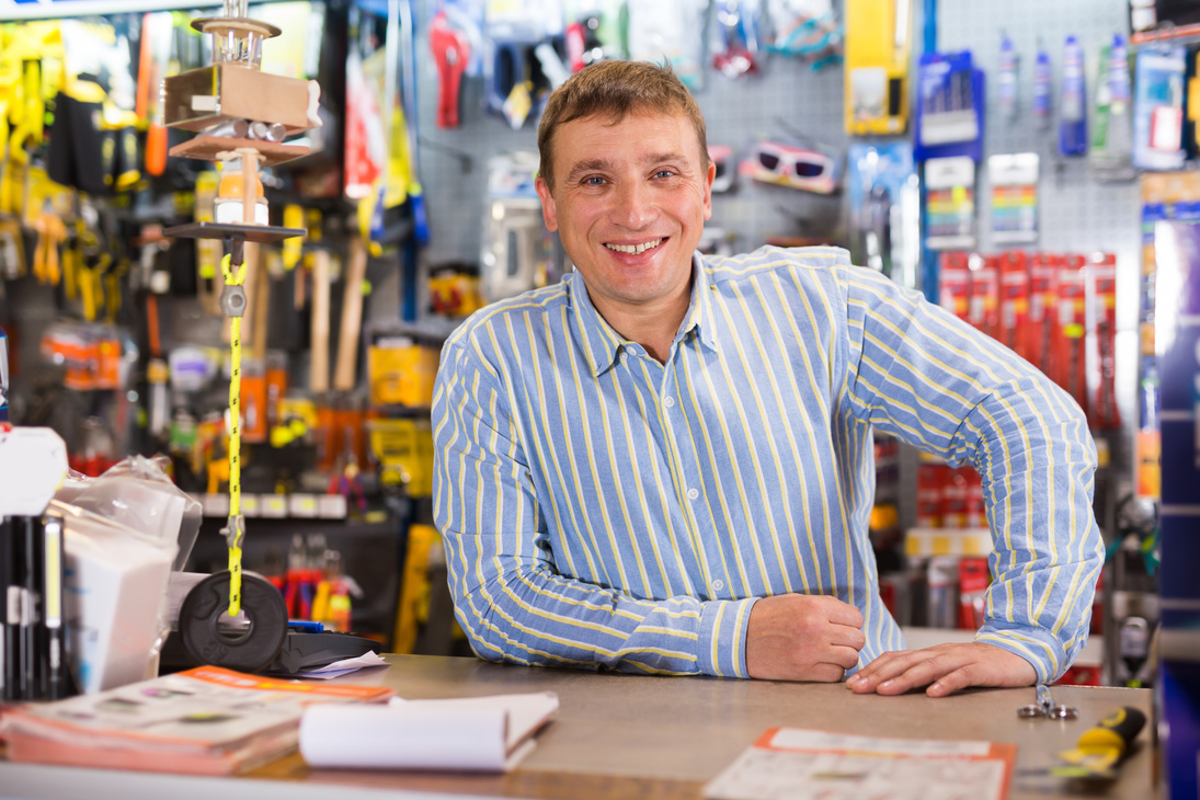 Fine seller man in store is trading tools